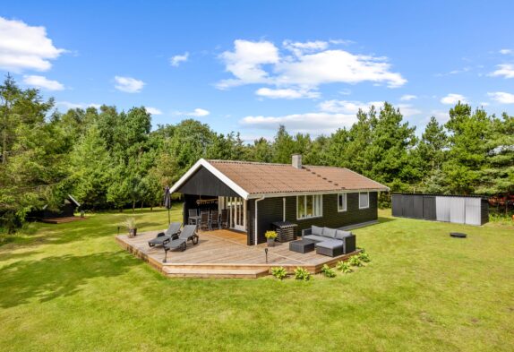 Hyggeligt træbeklædt sommerhus med shelter omgivet af skøn natur