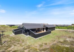 Træsommerhus med skønne terrasser og carport, tæt på havet