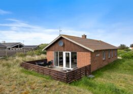 Lyst sommerhus med lukket terrasse mellem hav og fjord