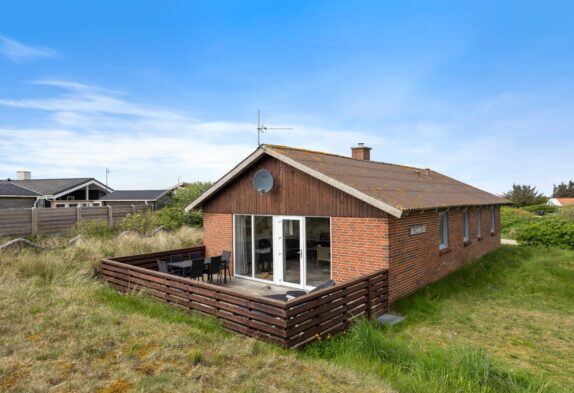 Lyst sommerhus med lukket terrasse mellem hav og fjord