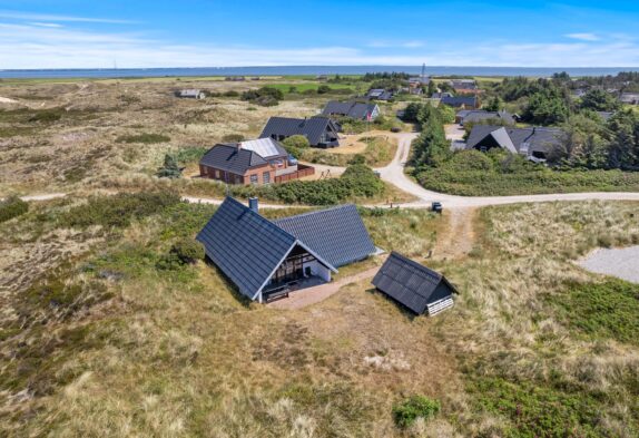 Moderne sommerhus med sauna beliggende på naturgrund