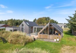 Firestjernet sommerhus med udebruser og lukket terrasse i Søndervig